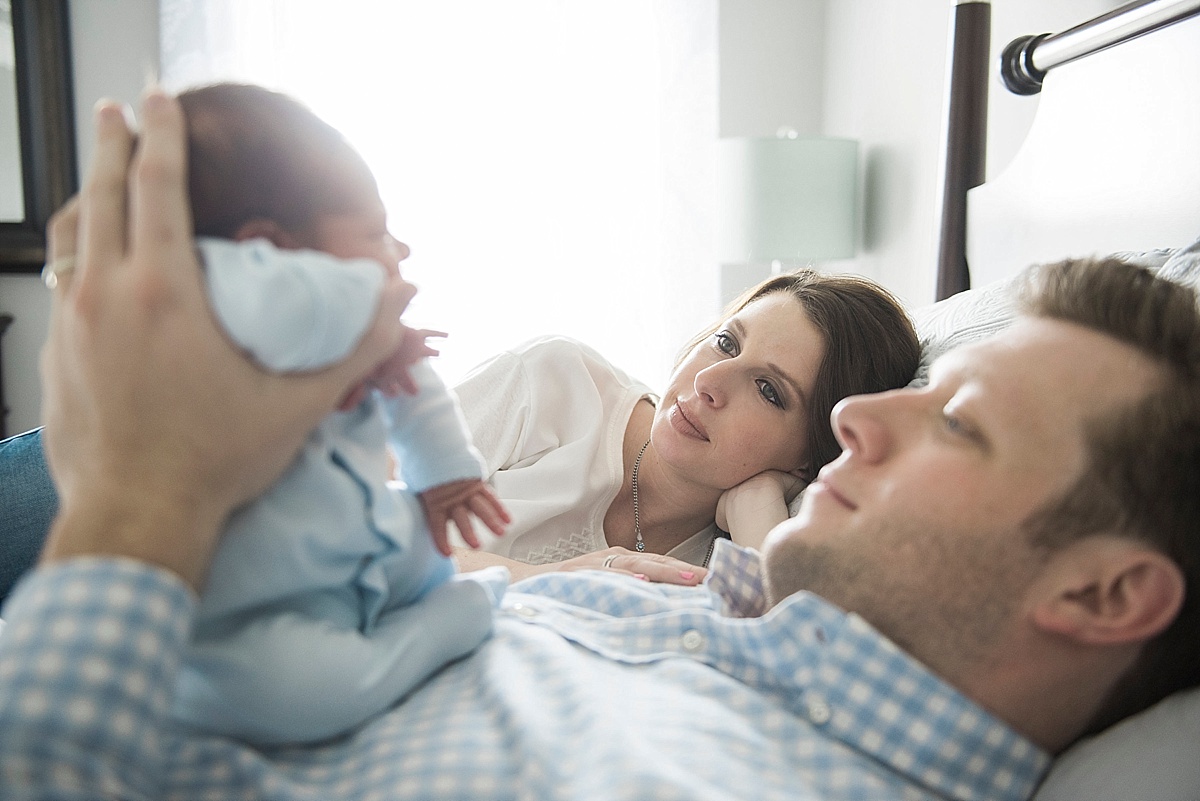 mom and dad look at newborn baby