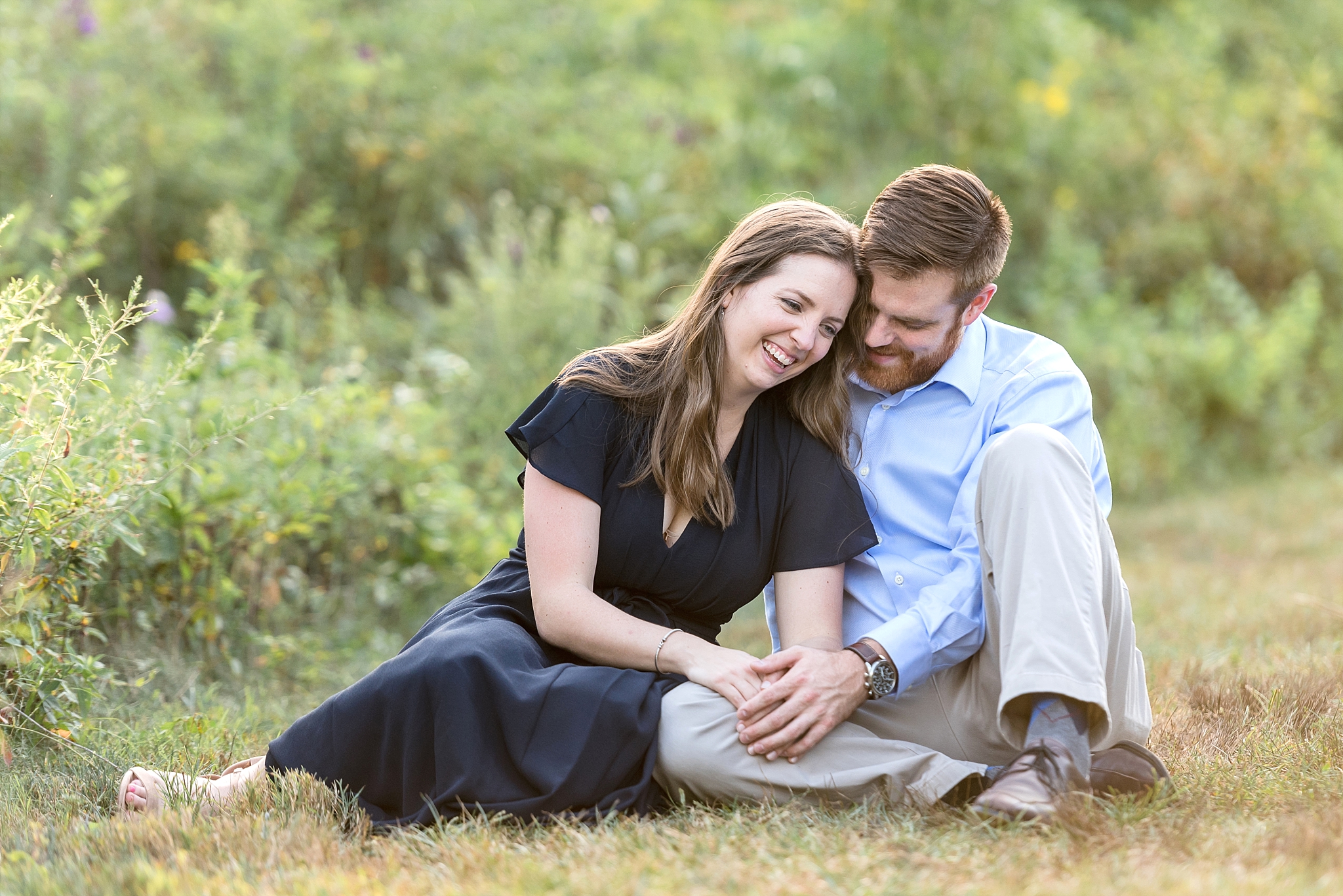 Couple sitting in grass laughing together