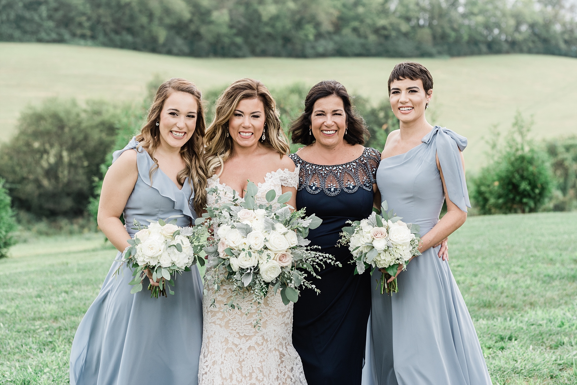 bridesmaids blue gray dresses white flowers