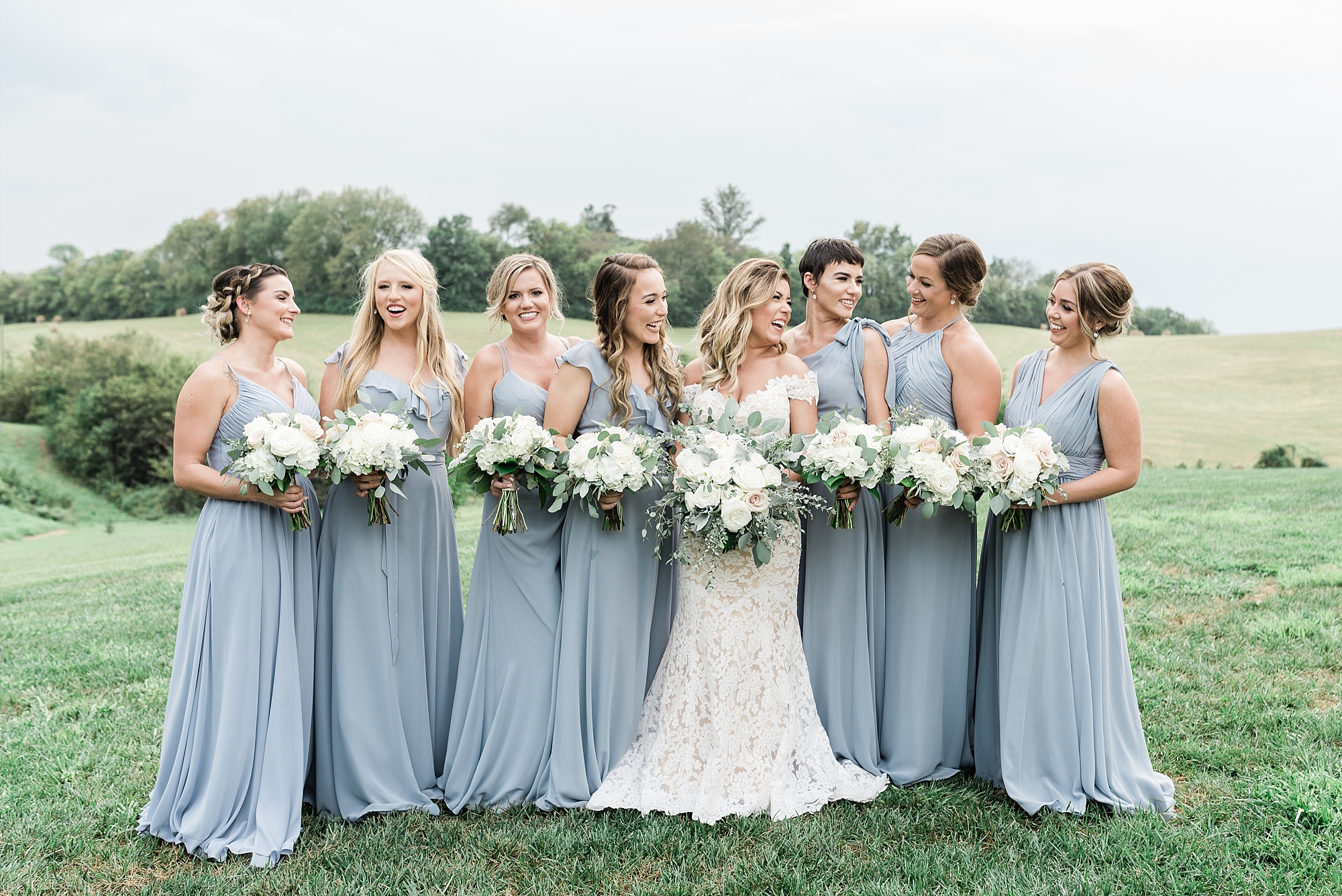 Bridesmaids blue gray dresses white flowers