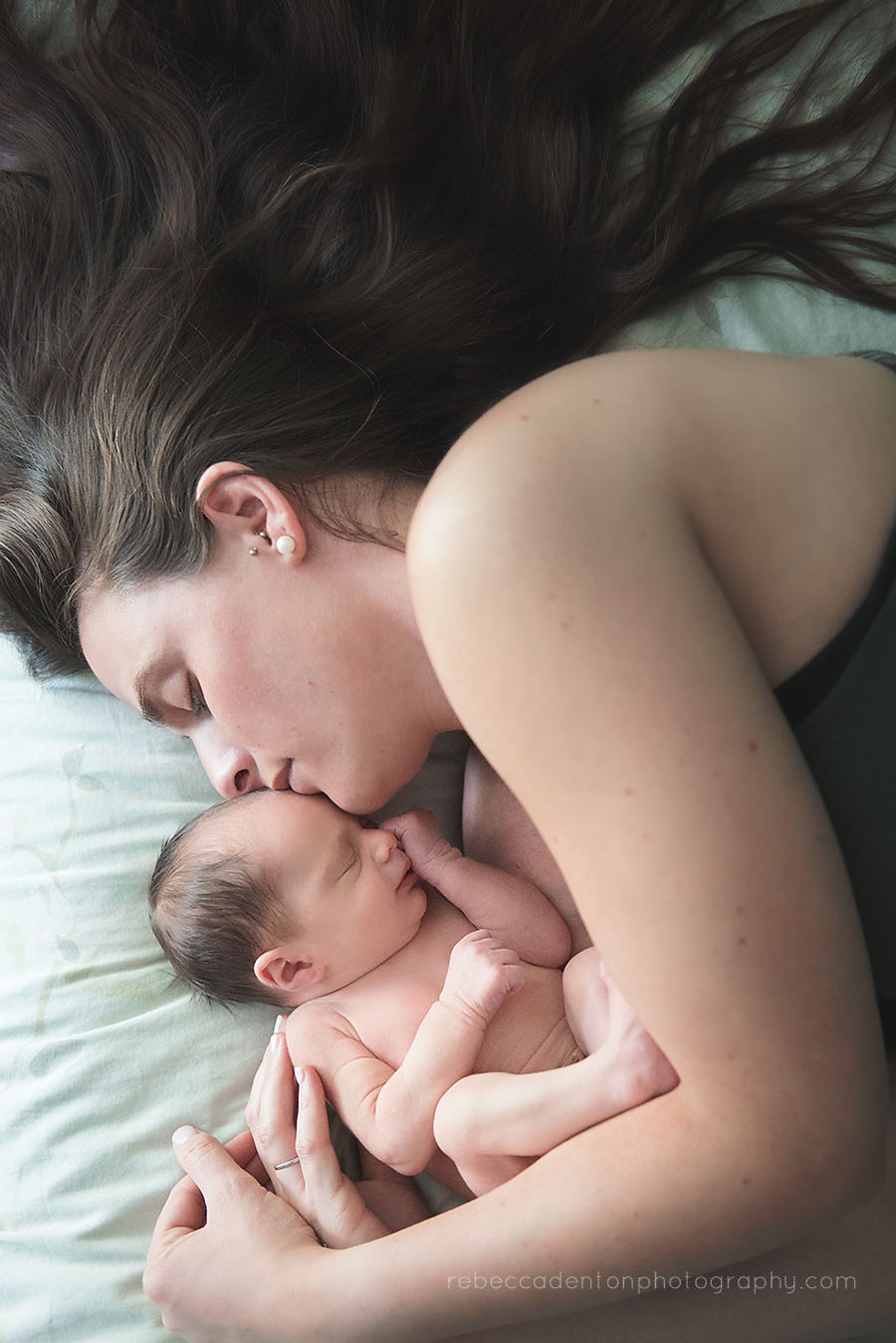 A mother snuggles with her newborn baby boy during a lifestyle newborn photography session in Nashville, Tennessee.