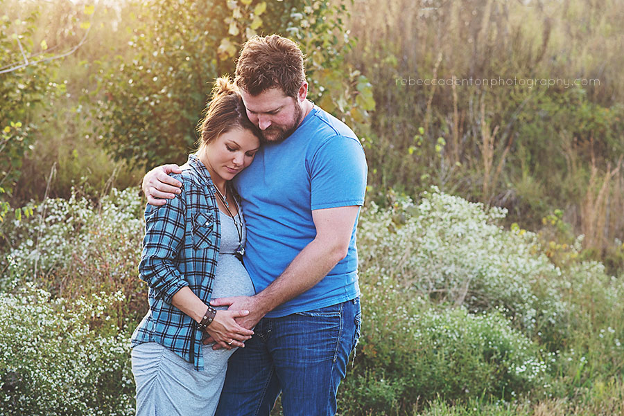 Couple hugging in field fall maternity photo