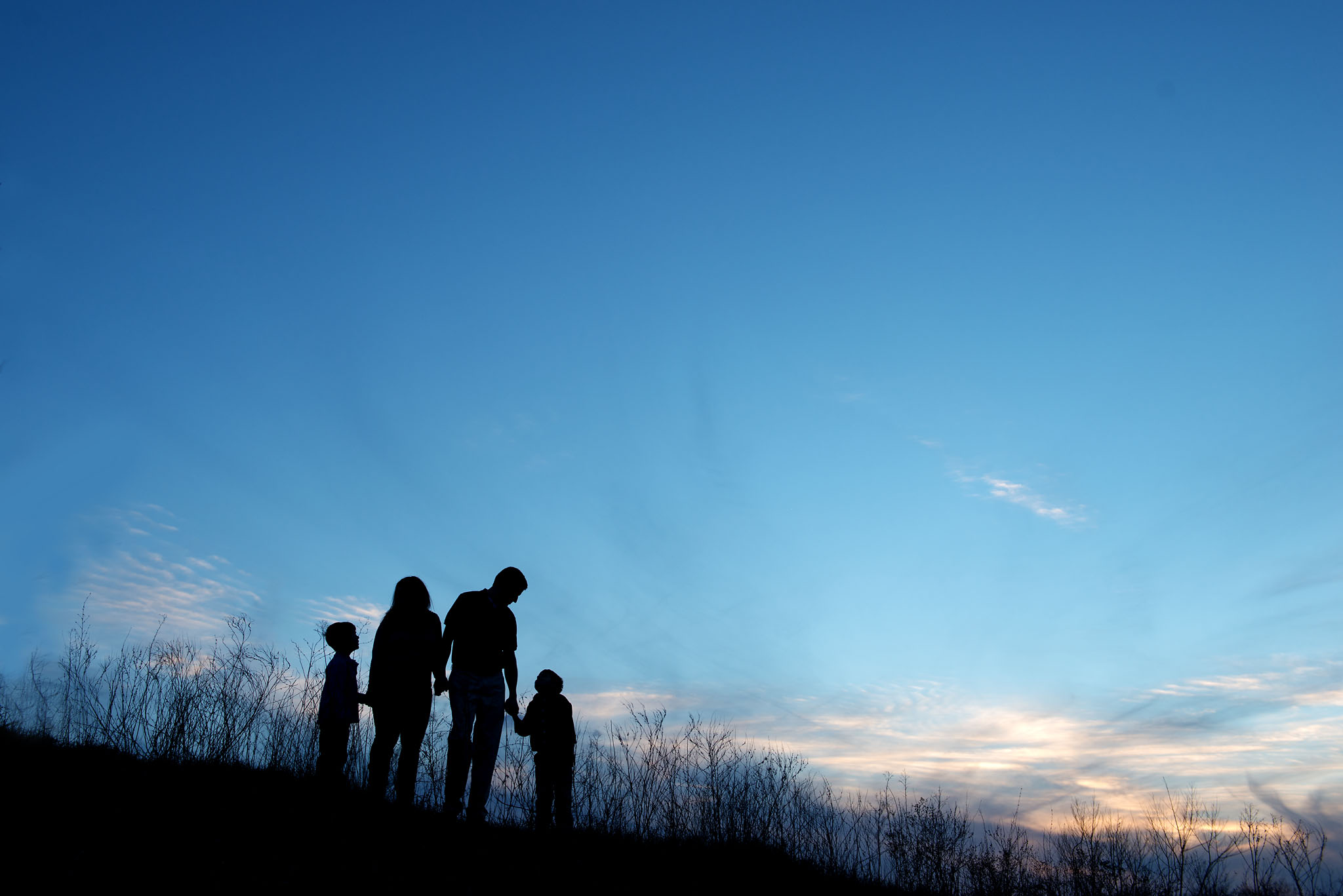 family silhouette at sunset