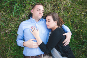 Engaged couple lying in grass