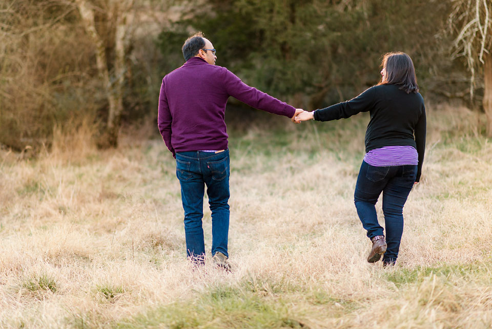 couple holding hands in field maternity photography nashville