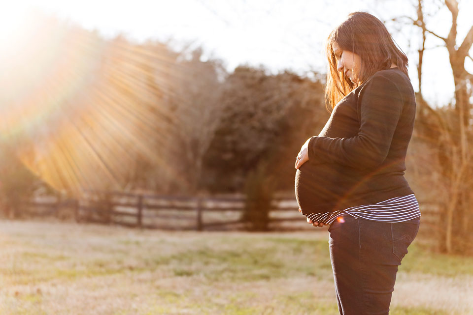 backlight maternity photograph in field