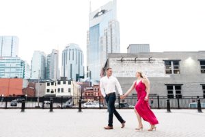 couple running in downtown Nashville with Batman building