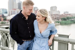 Couple laughing together on pedestrian bridge in Nashville