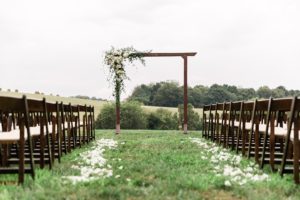 outdoor wedding ceremony flower arch white roses greenery Enchanted Florist